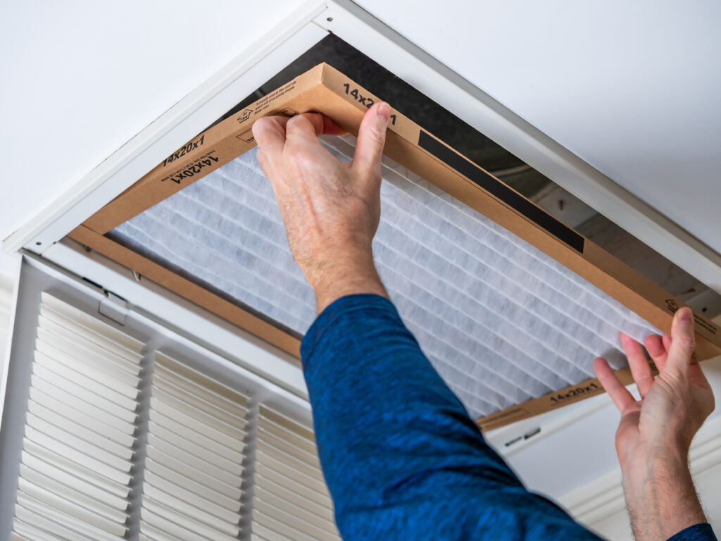 HVAC technician replacing a home air filter in Torrance