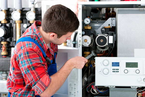 Heating technician repairing boiler controls in Torrance