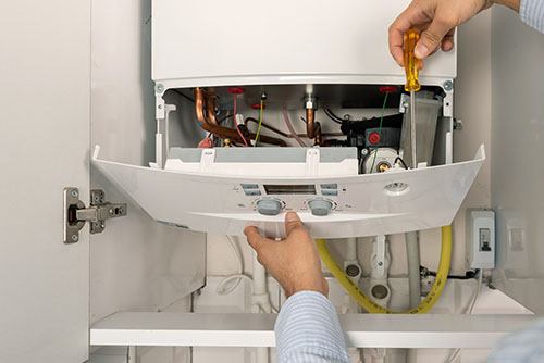 Heating technician repairing a residential boiler in Torrance