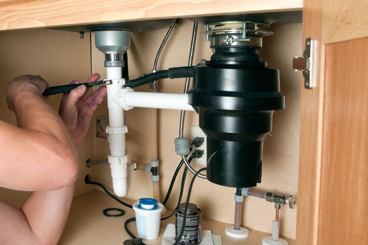 Plumber repairing a garbage disposal in Torrance
