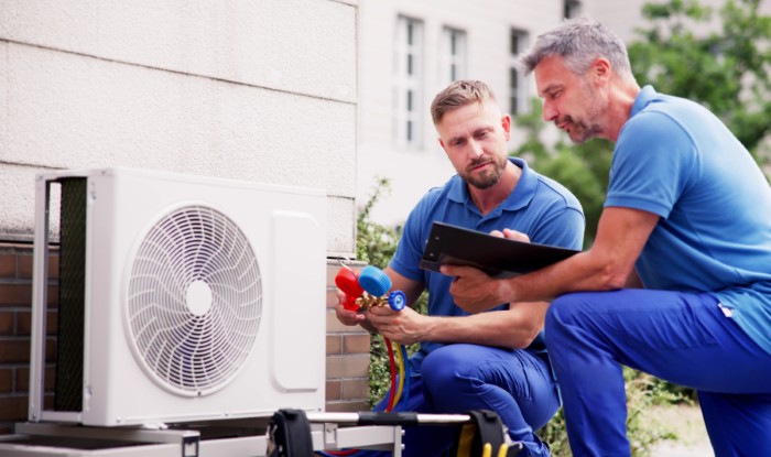 HVAC technicians installing an outdoor air conditioning unit in Torrance