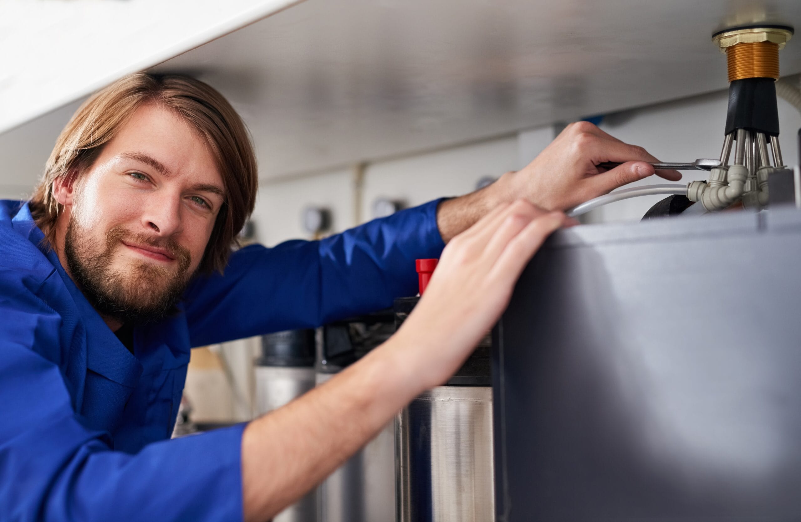 Technician servicing a residential water heater tank in Torrance